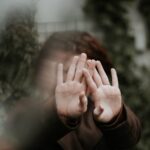 person in brown long sleeve shirt covering face with hand